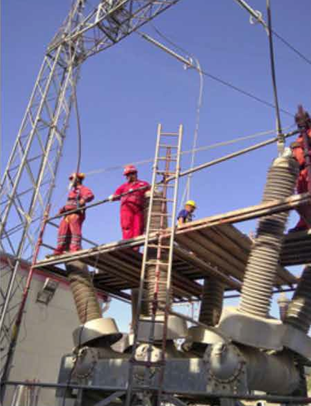 Trabajadores en plataforma realizando mantenimiento en equipo de alta tensión