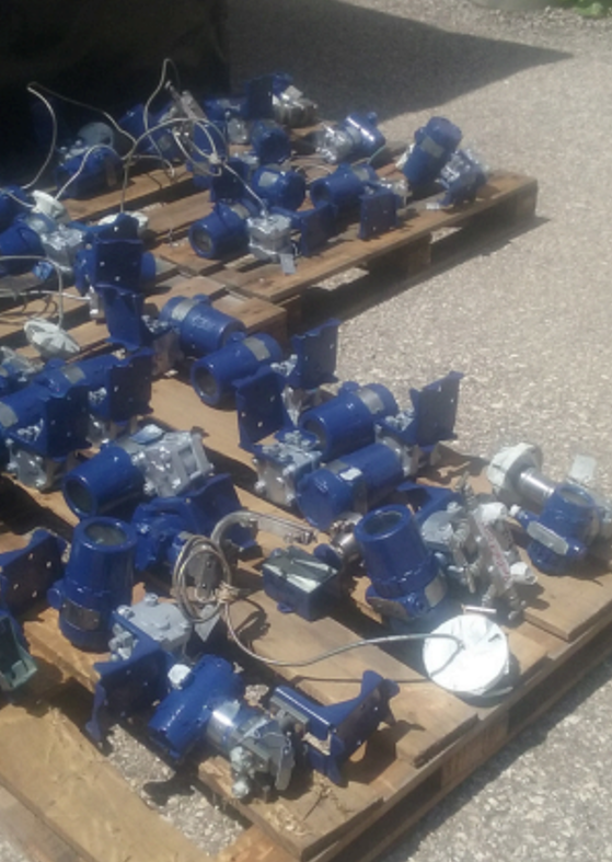 Válvulas y actuadores industriales en palés, área de preparación