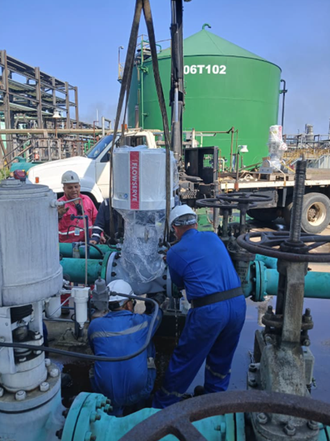 Operarios en instalación de equipo industrial FLOWSERVE en planta petroquímica