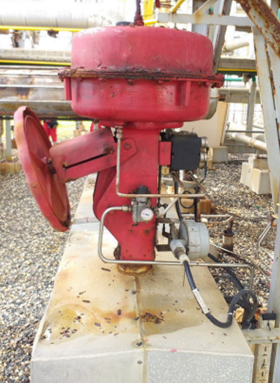 Válvula de control industrial roja con actuador y instrumentación en planta